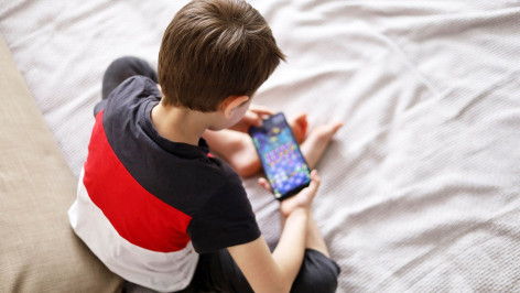 ребенок играет в игру на смартфоне