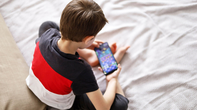 ребенок играет в игру на смартфоне