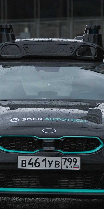 Пассажиры садятся в салон беспилотного автомобиля Sberautotech в Москве
