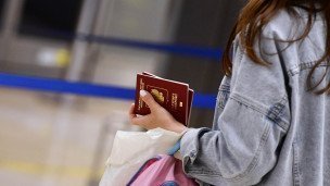 Девушка в международном аэропорту с загранпаспортом 