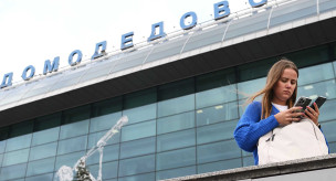 Девушка с телефоном около аэропорта