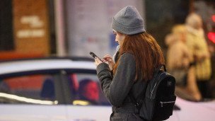 Женщина с телефоном на одной из улиц города