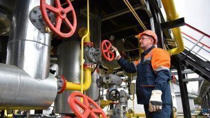 Газодобывающее предприятие сотрудник поворачивает вентиль