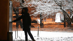 человек открывает дверь в подъезд