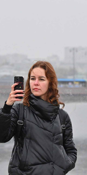 девушка с телефоном во время прогулки по москве