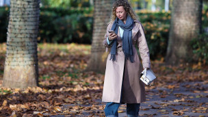 Девушка со смартфоном гуляет в парке