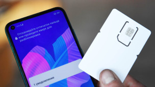 сим-карта и смартфон в руке