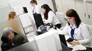 Сотрудницы банка ведут прием посетителей 