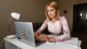 Женщина за компьютером работает из дома