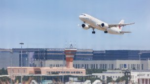 Самолет в небе над аэропортом 