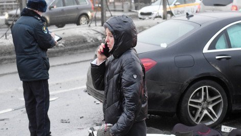Девушка звонит по телефону возле автомобилей, пострадавших в результате ДТП