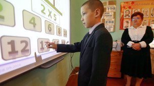 На уроке математики ученик у интерактивной доски 