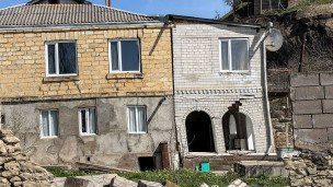 Вид на жилой дом, разрушенный в результате оползней