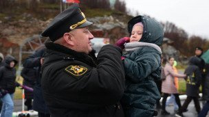 Ребенок на руках у мужчины в рабочей форме моряка