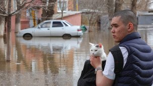 Мужчина с котом около подтопленного дома