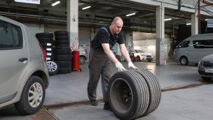 Работник автосервиса во время смены резины