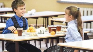 Учащиеся школы во время обеда в столовой