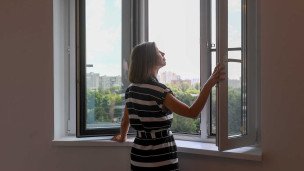 Женщина у окна в новой квартире