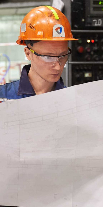 Рабочий на заводе с чертежом