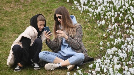 Женщина с ребенком смотрят в телефон