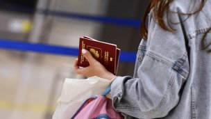 девушка держит в руках паспорт