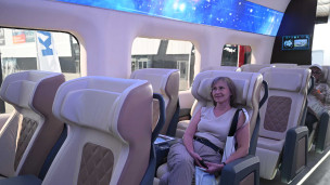 Посетители в полноразмерном макете сверхскоростного поезда для ВСМ