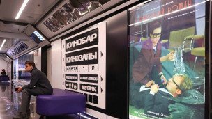 Мужчина в кинотеатре Центрального детского магазина у афиши фильма режиссера Эльдара Рязанова "Служебный роман"
