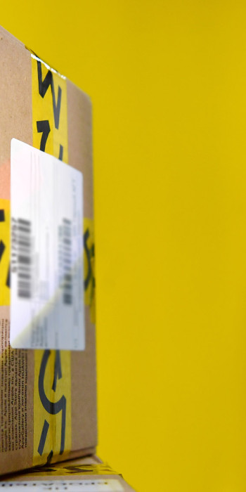 Сотрудник сканирует штрих-код с коробки в пункте выдачи заказов 