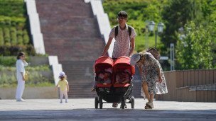 Прохожие на набережной родители с колясками