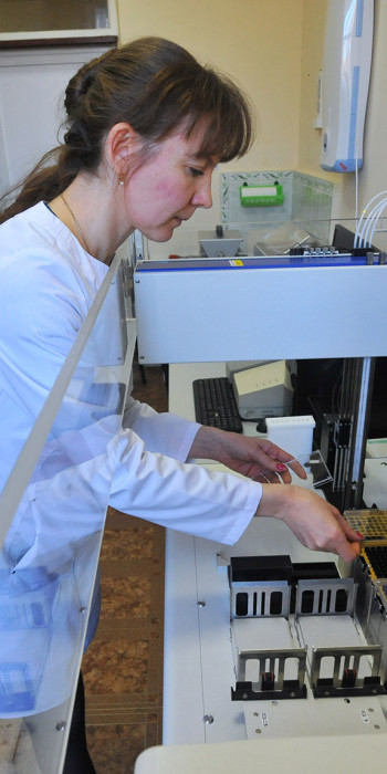 Врач-лаборант работает на аппарате для диагностики ВПЧ