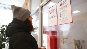 Женщина читает объявление о "Мобильном избирателе"