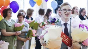 выпускник с букетами цветов в руках