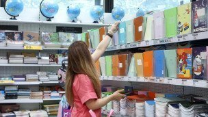 Посетительница выбирает тетради 