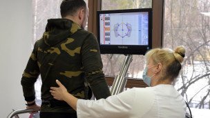 Медицинский работник помогает участнику специальной военной операции