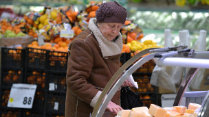 Пожилая женщина выбирает в магазине