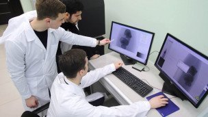 Врач показывает коллегам рентген на мониторе 