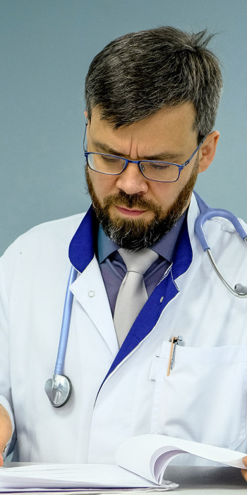Врач читает историю болезни пациента 