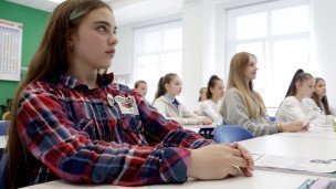 Школьница за партой в классе во время урока