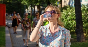 Девушка на улице пьет воду 