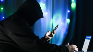 Мужчина держит в руках мобильный телефон