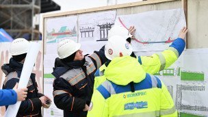 Строители в касках смотрят на чертеж