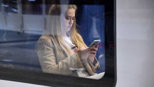 Девушка с телефоном в вагоне поезда