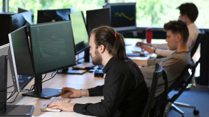 Сотрудники перед мониторами в офисе