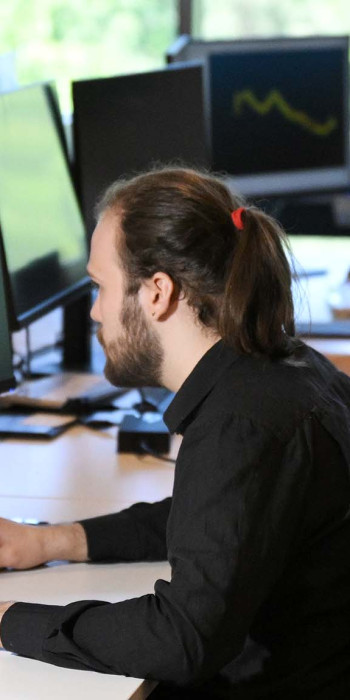 Сотрудники перед мониторами в офисе