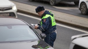 Сотрудник ДПС проверяет документы у водителя