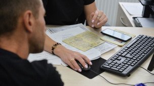 Сотрудница помогает посетителю с документами