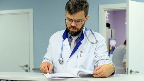 Врач читает историю болезни пациента 