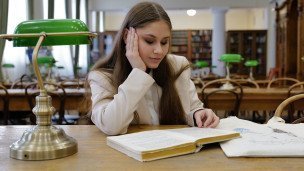 Студентка в читальном зале библиотеки университета