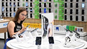 Девушка в магазине выбирает смартфон
