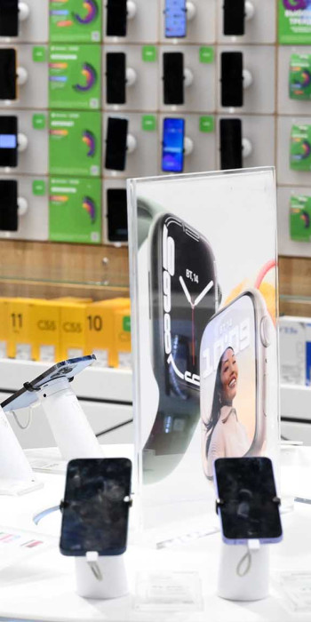 Девушка в магазине выбирает смартфон
